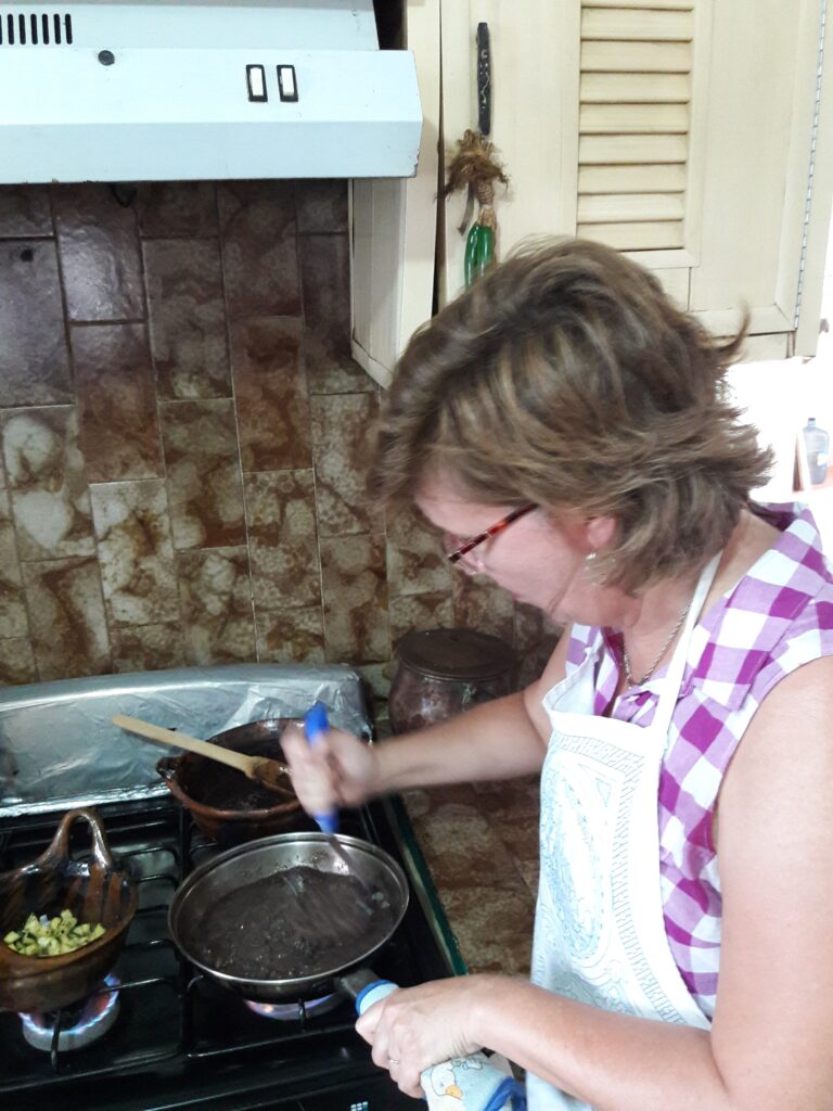 Woman mashing beans in a pan on the stovetop