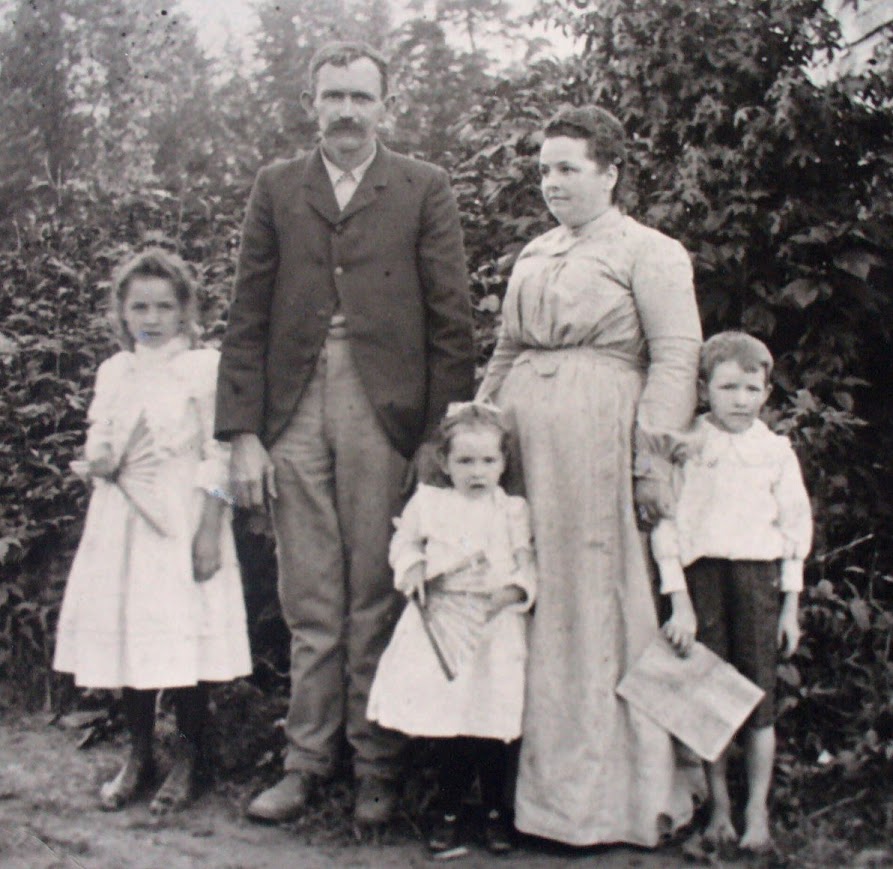 Family of 5 with father, mother 2 young girls and one young boy. Black and white Photo from 1906