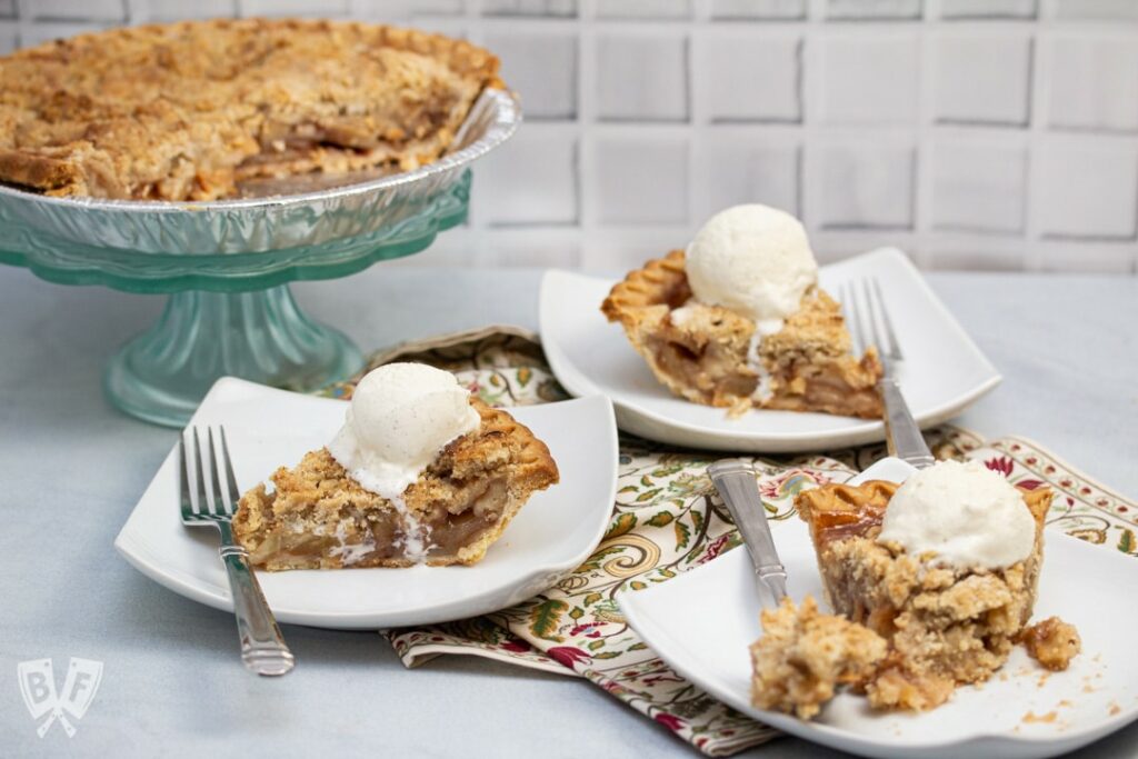 White plates of Dutch Apple Pie with vanilla ice cream on top