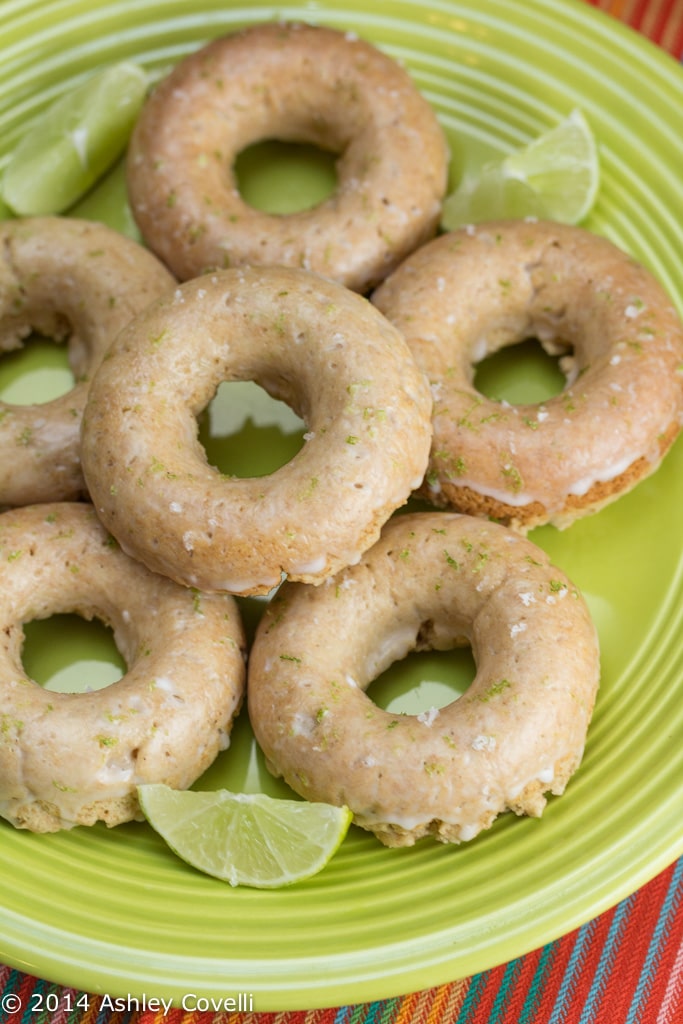 Donuts on green plate with slices of lime