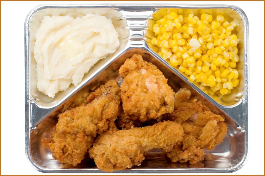 Old fashioned TV dinner with fried chicken, mashed potatoes and corn